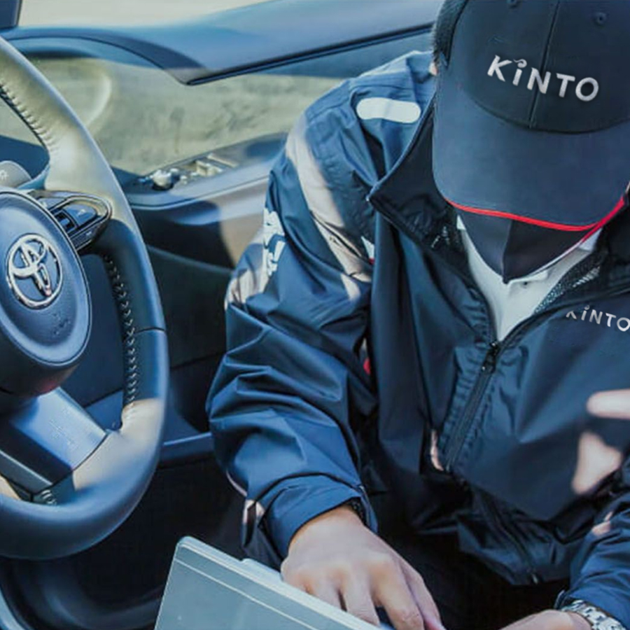 A KINTO maintenance inspector inside a Toyota car